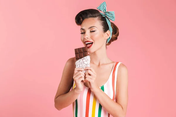 若いピンは チョコレートを食べるピンクの壁の背景に分離された女性の画像 — ストック写真