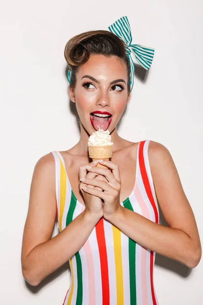 Image of beautiful pin up woman isolated over white wall background eating ice cream.