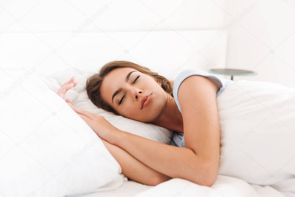 Close up of a pretty young woman sleeping in bed