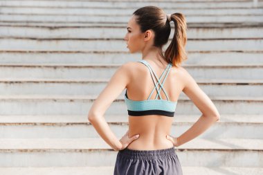 Arkadan spor giyim ayakta açık havada merdivenlerde giymiş genç bir sporcumuz görünüşü