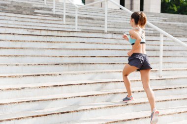 Spor giyim merdivenlerden yukarı açık havada çalışan genç bir sporcumuz tam uzunlukta arkadan görünüm giymiş