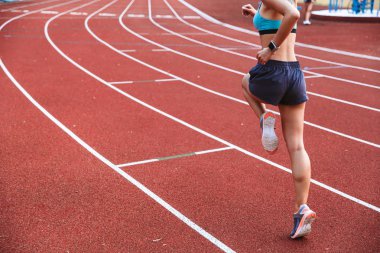 Stadyumda uzaktan çalışan bir sporcumuz arkadan görünüm kırpılmış görüntü
