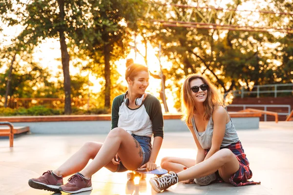 Two Cheerful Young Girls Having Fun While Sitting Skateboard Park — Stock Photo, Image