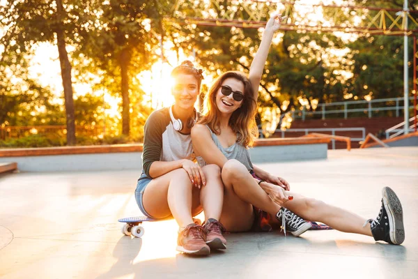 Dos Chicas Jóvenes Emocionadas Divirtiéndose Mientras Sientan Con Monopatín Parque — Foto de Stock