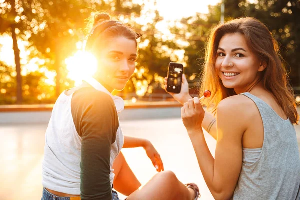 Dos Chicas Jóvenes Sonrientes Divirtiéndose Mientras Sientan Toman Una Selfie — Foto de Stock