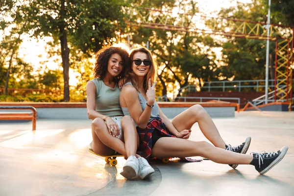 Duas Jovens Garotas Alegres Divertindo Enquanto Sentam Com Skate Parque — Fotografia de Stock