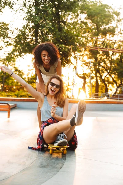 Две Улыбающиеся Девушки Веселятся Катаясь Скейтборде Парке — стоковое фото