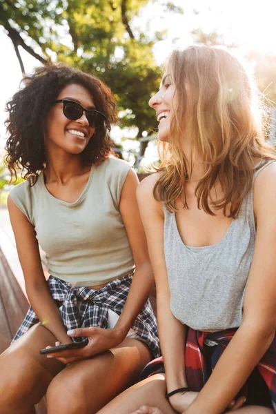 Dos Chicas Riendo Divirtiéndose Juntas Mientras Están Sentadas Con Teléfono —  Fotos de Stock