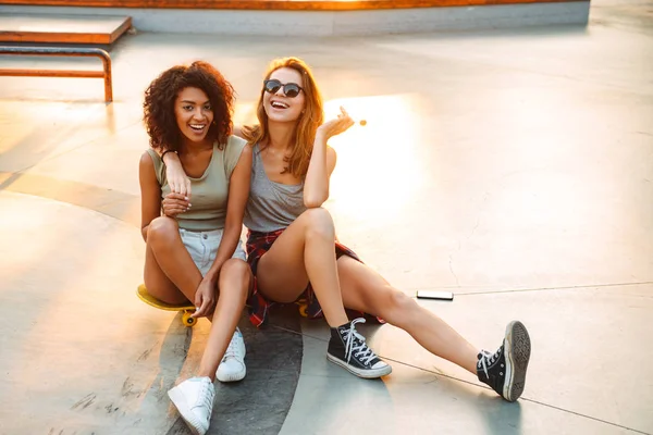 Duas Jovens Garotas Alegres Divertindo Enquanto Sentam Com Skate Parque — Fotografia de Stock