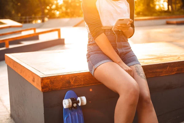 Beskuren Bild Ung Flicka Med Hörlurar Som Håller Mobiltelefon Medan — Stockfoto