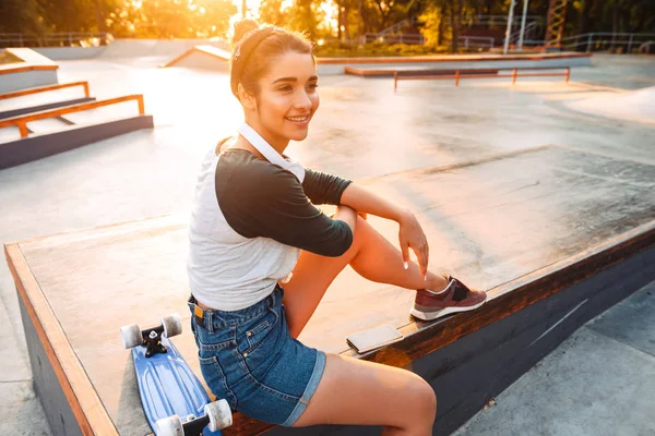 Glad Ung Flicka Med Hörlurar Och Skateboard Sitter Park — Stockfoto