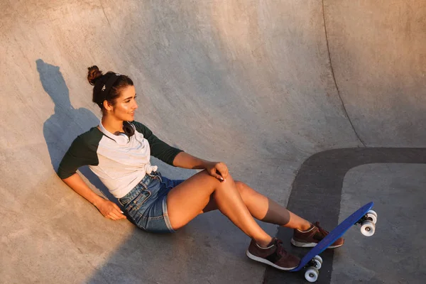 Chica Joven Sonriente Con Auriculares Monopatín Sentado Rampa — Foto de Stock