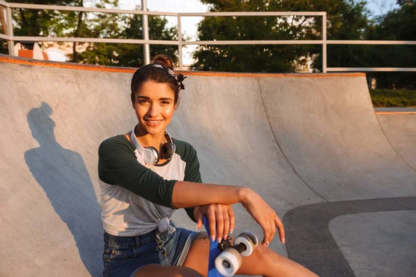 Vrolijk Meisje Met Hoofdtelefoons Skateboard Zit Bij Helling — Stockfoto