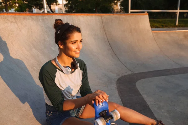 Vrolijke Jonge Meisje Met Hoofdtelefoons Skateboard Zit Bij Helling — Stockfoto