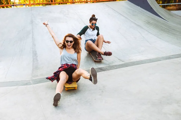 Duas Jovens Garotas Alegres Divertindo Enquanto Andam Skate Parque — Fotografia de Stock