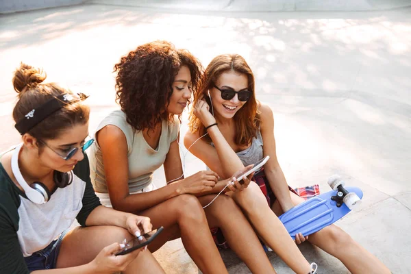 Tres Chicas Jóvenes Emocionadas Divirtiéndose Mientras Sientan Con Teléfonos Móviles — Foto de Stock