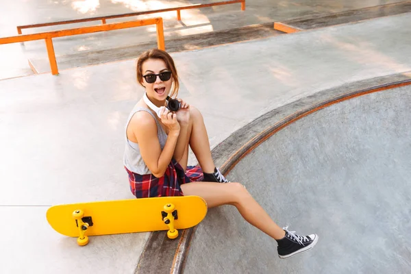 Ενθουσιασμένος Νεαρό Κορίτσι Ακουστικά Ακούτε Μουσική Ενώ Κάθεται Skateboard Ένα — Φωτογραφία Αρχείου