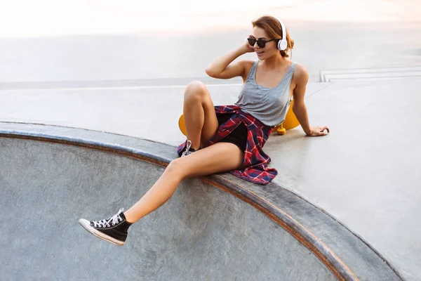 Sorrindo Menina Fones Ouvido Ouvindo Música Enquanto Sentado Com Skate — Fotografia de Stock