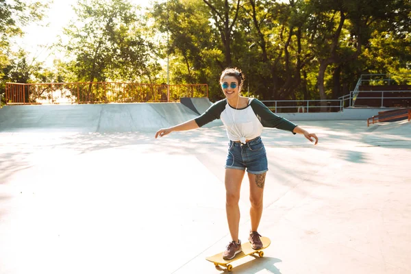 Foto Van Gelukkig Vrolijke Jongedame Buiten Wandelen Met Skateboard Luisteren — Stockfoto