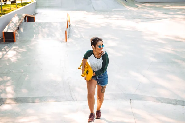 Glimlachend Jong Meisje Eaephones Rijden Een Skateboard Een Park — Stockfoto