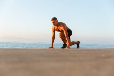 Plajda yayınlanmaya başlaması hazır Başlarken kulaklık ile kendine güvenen sporcu