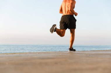 Plajda çalışan gömleksiz sporcu görüntü kırpılmış arkadan görünüm