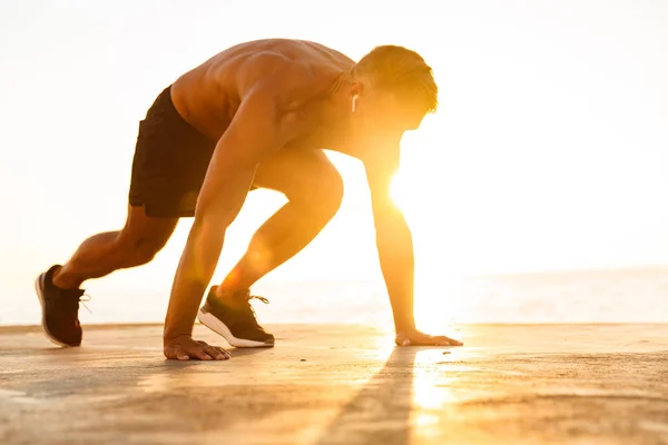 Уверенный Спортсмен Наушниками Готовящийся Бегать Пляже Солнечном Свете — стоковое фото