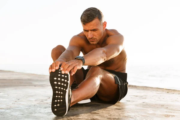 Pohledný Shirtless Sportovec Dělá Protahovací Cvičení Pláži — Stock fotografie