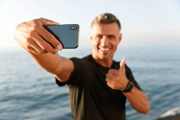 Sorridente Bello Sportivo Senza Maglietta Prendendo Selfie Mentre Piedi Spiaggia — Foto Stock