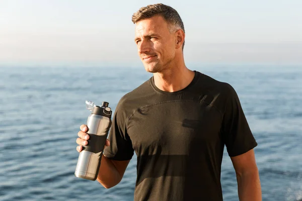Photo Handsome Strong Mature Sportsman Standing Bottle Water Drinking Beach — Stock Photo, Image