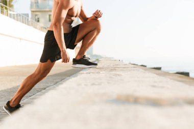 Germe egzersizleri üzerinde plaj açık havada güçlü olgun sporcu yapmak kırpılmış görüntü.