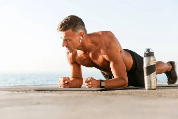 Motivated Shortless Sportsman Earphones Doing Plank Exercises Fitness Mat Beach — Stock Photo, Image