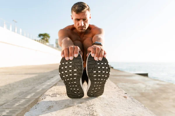 Desportista Sem Camisa Motivado Fones Ouvido Fazendo Exercícios Alongamento Praia — Fotografia de Stock