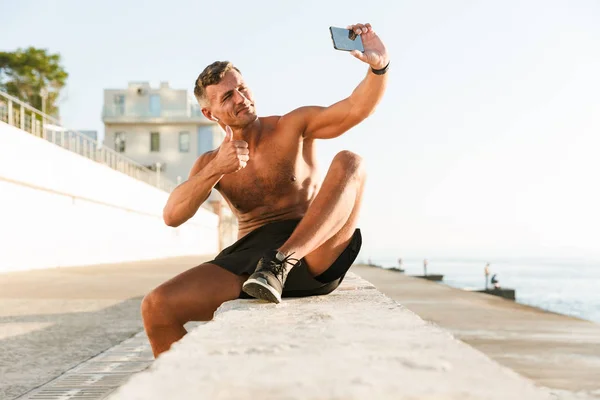 Sonriente Deportista Guapo Sin Camisa Con Auriculares Tomando Una Selfie — Foto de Stock