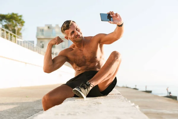 Sonriente Deportista Guapo Sin Camisa Con Auriculares Tomando Una Selfie — Foto de Stock