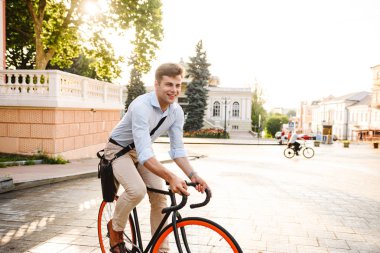 Mutlu genç şık adam bir şehir sokak bir bisiklet sürme gömlek giymiş