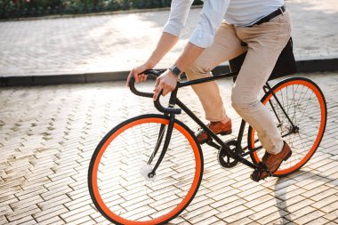 Genç adam bir şehir sokak bir bisiklet sürme gömlek giymiş görüntü kırpılmış