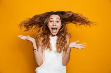Portrait of a happy young girl screaming isolated over yellow background clipart