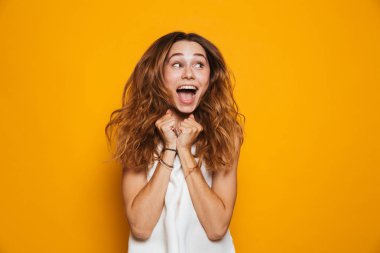 Sarı arka plan üzerinde izole portre heyecanlı bir genç kızın çığlık