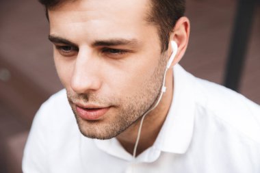 Kulaklıklar açık havada yakışıklı bir genç adam portresi kapatın