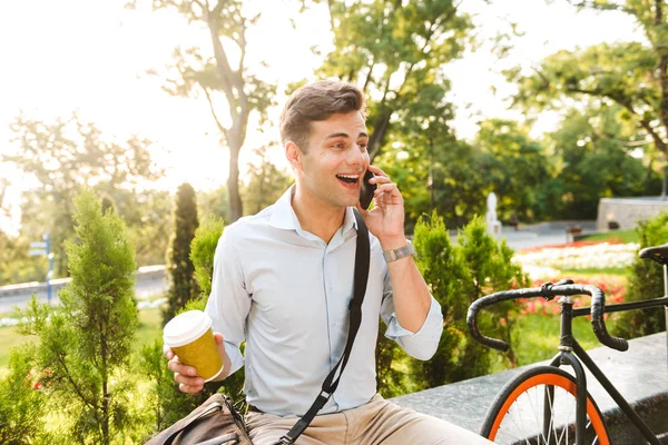 Cheerful Young Stylish Man Talking Mobile Phone While Drinking Coffee — Stock Photo, Image