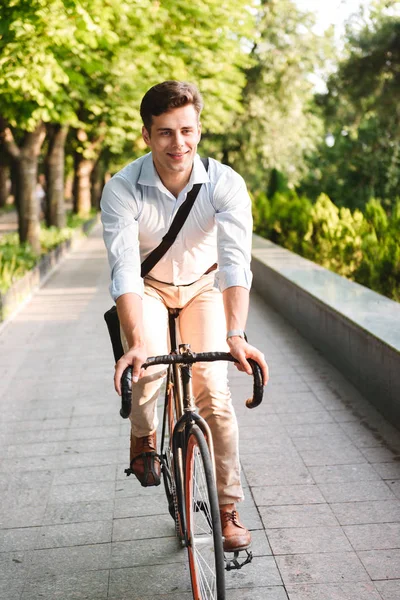 屋外自転車に乗ってのバッグとシャツを着たハンサムな若い男の肖像 — ストック写真