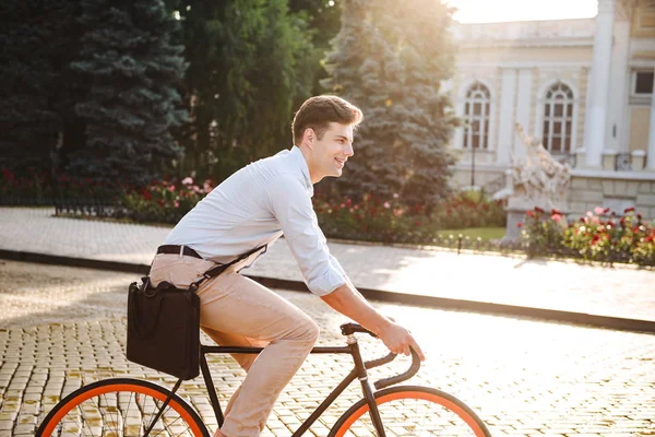 魅力的なスタイリッシュな若者が街で自転車に乗ってシャツに身を包んだ — ストック写真