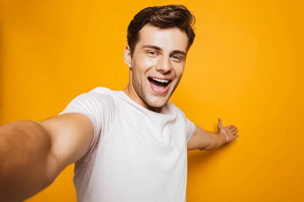 Portrét Veselý Mladý Muž Selfie Outsretched Rukou Nad Žlutým Pozadím — Stock fotografie