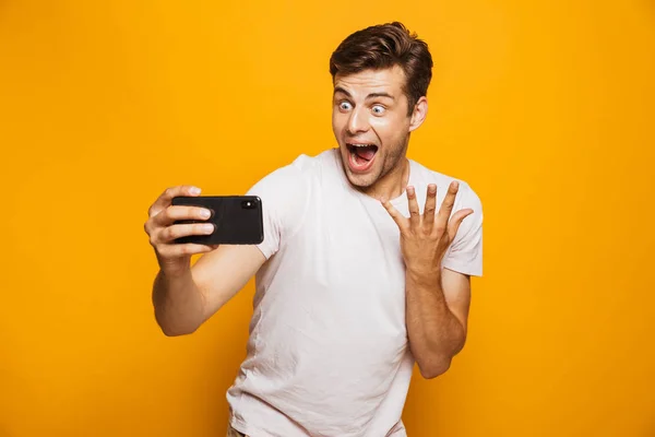 うれしそうな若い男の黄色背景に分離された Selfie を取って成功を祝う肖像画 — ストック写真