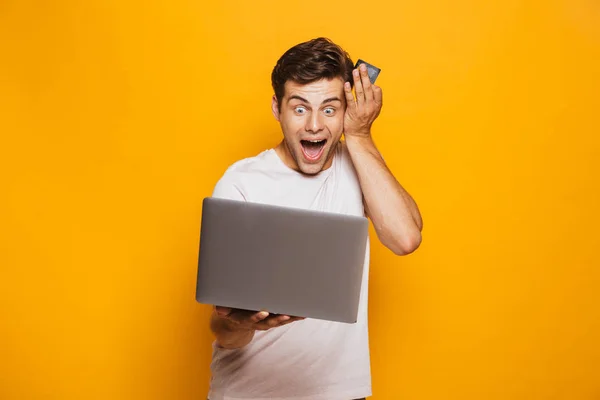 Retrato Jovem Espantado Segurando Computador Portátil Mostrando Cartão Crédito Isolado — Fotografia de Stock