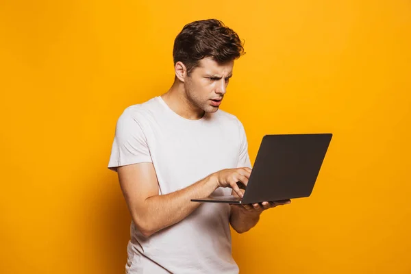 Retrato Jovem Concentrado Usando Computador Portátil Isolado Sobre Fundo Amarelo — Fotografia de Stock