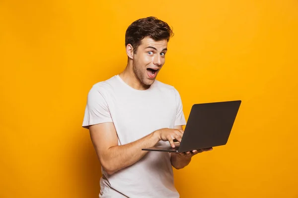 Portret Van Een Enthousiast Jonge Man Met Laptopcomputer Geïsoleerd Gele — Stockfoto