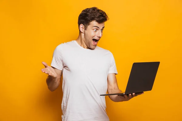 Retrato Jovem Emocionado Usando Computador Portátil Isolado Sobre Fundo Amarelo — Fotografia de Stock