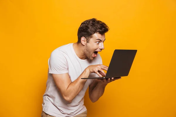 Egy Laptop Számítógép Izolált Sárga Háttér Segítségével Izgatott Fiatalember Portréja — Stock Fotó